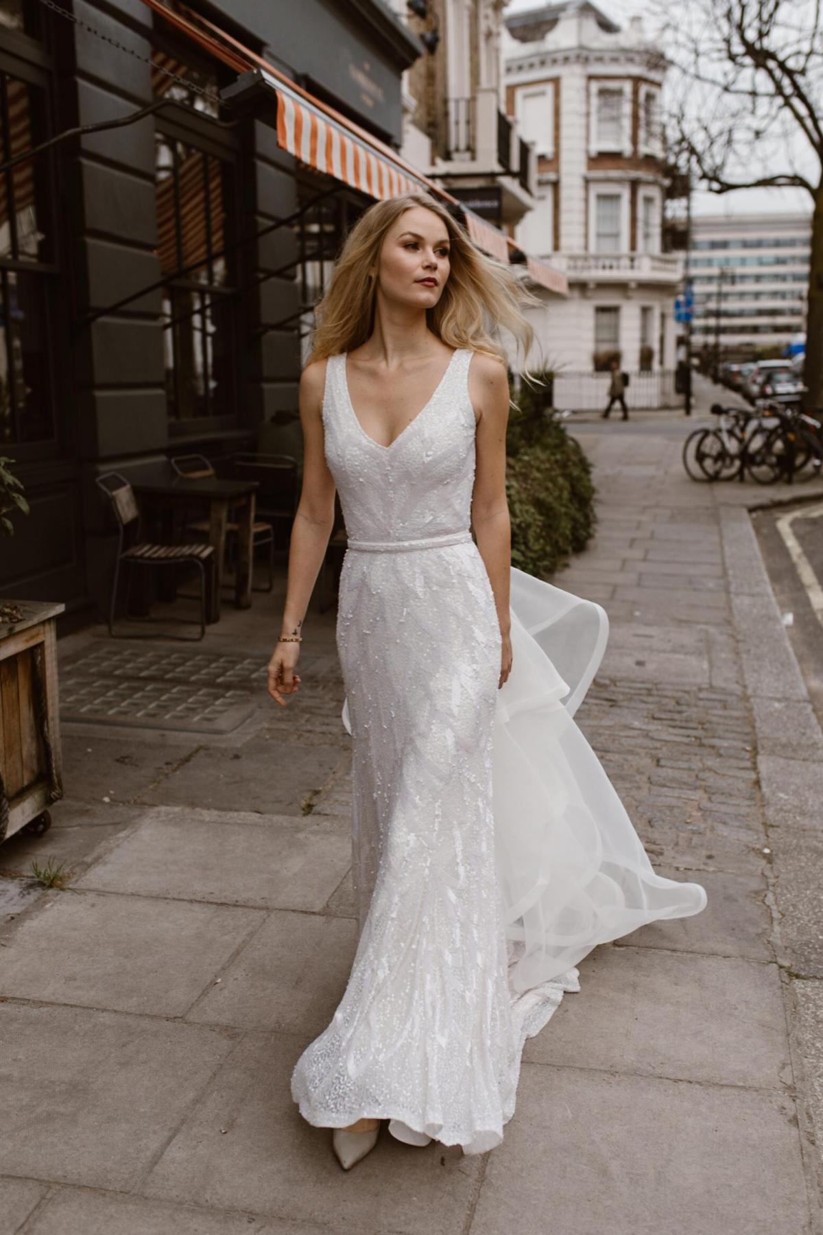 The Rhiannon gown by Karen Willis Holmes, v-neck beaded wedding dress shown with detachable train.