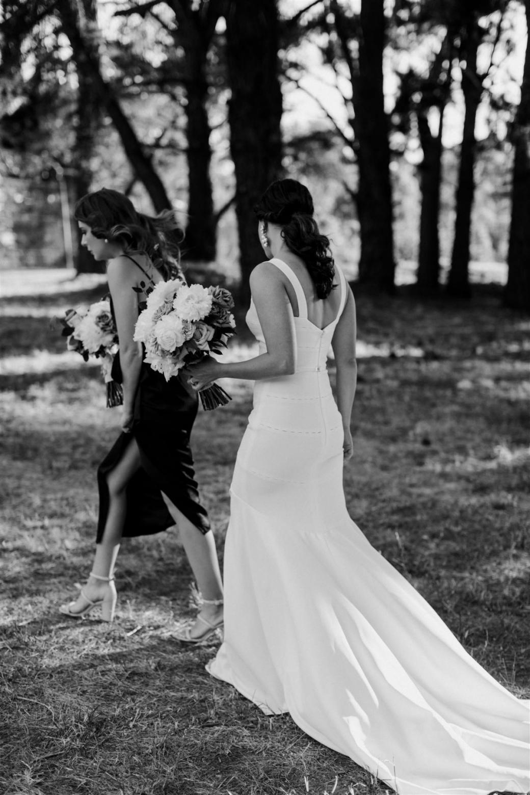 KWH real bride Rachael walking with a timeless bouquet. Rachael wears our minimalistic Violet gown.