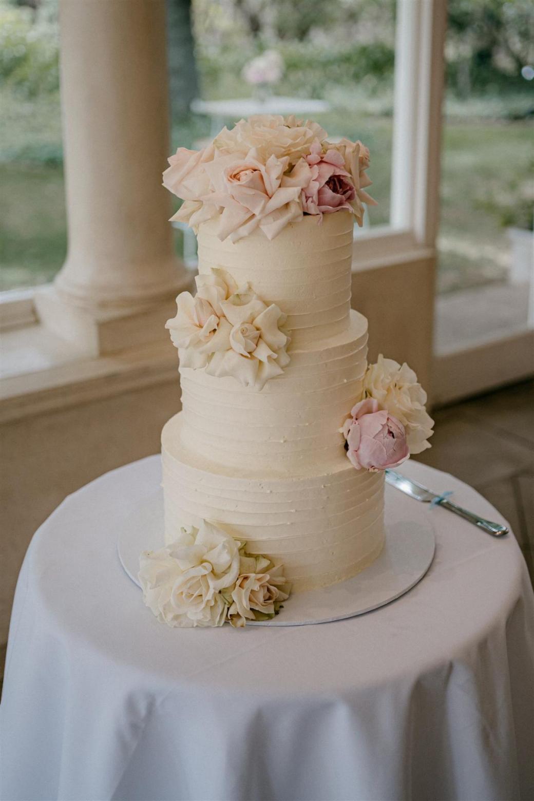 KWH bride Ashleigh's cream wedding cake, featuring a rose floral detail.