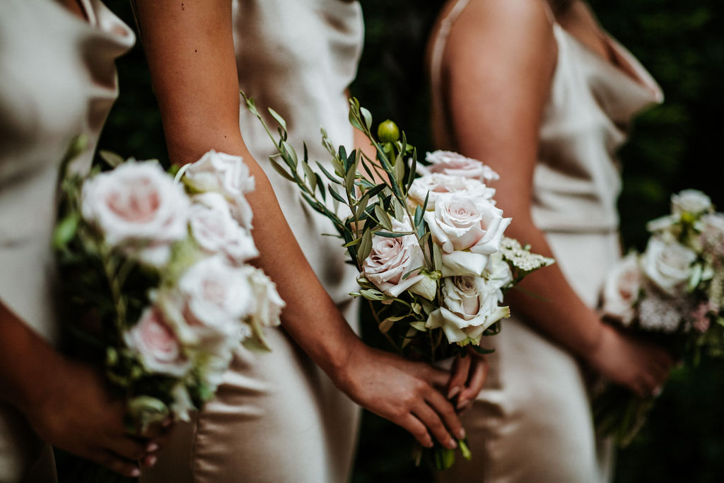 Champagne dressed bridesmaids holding rose florals at KWH bride Win's wedding.
