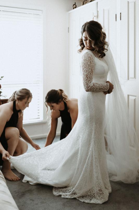 Karen Willis Holmes bride Meagan getting reading with her bridesmaids, the Wild Hearts Karina gown; a flattering long-sleeved lace wedding dress for the modern bohemian bride.