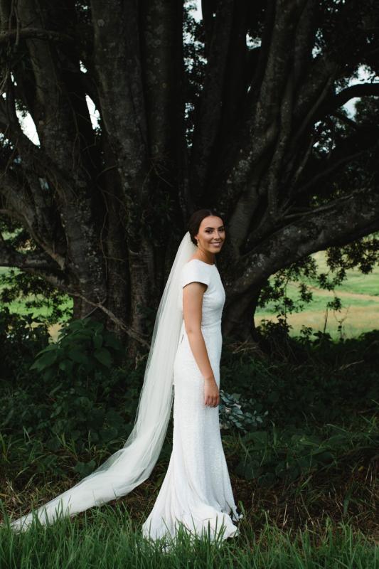 Real bride Elly poses at country wedding wearing the Annette gown by Karen Willis Holmes; a beaded wedding dress with a low back.