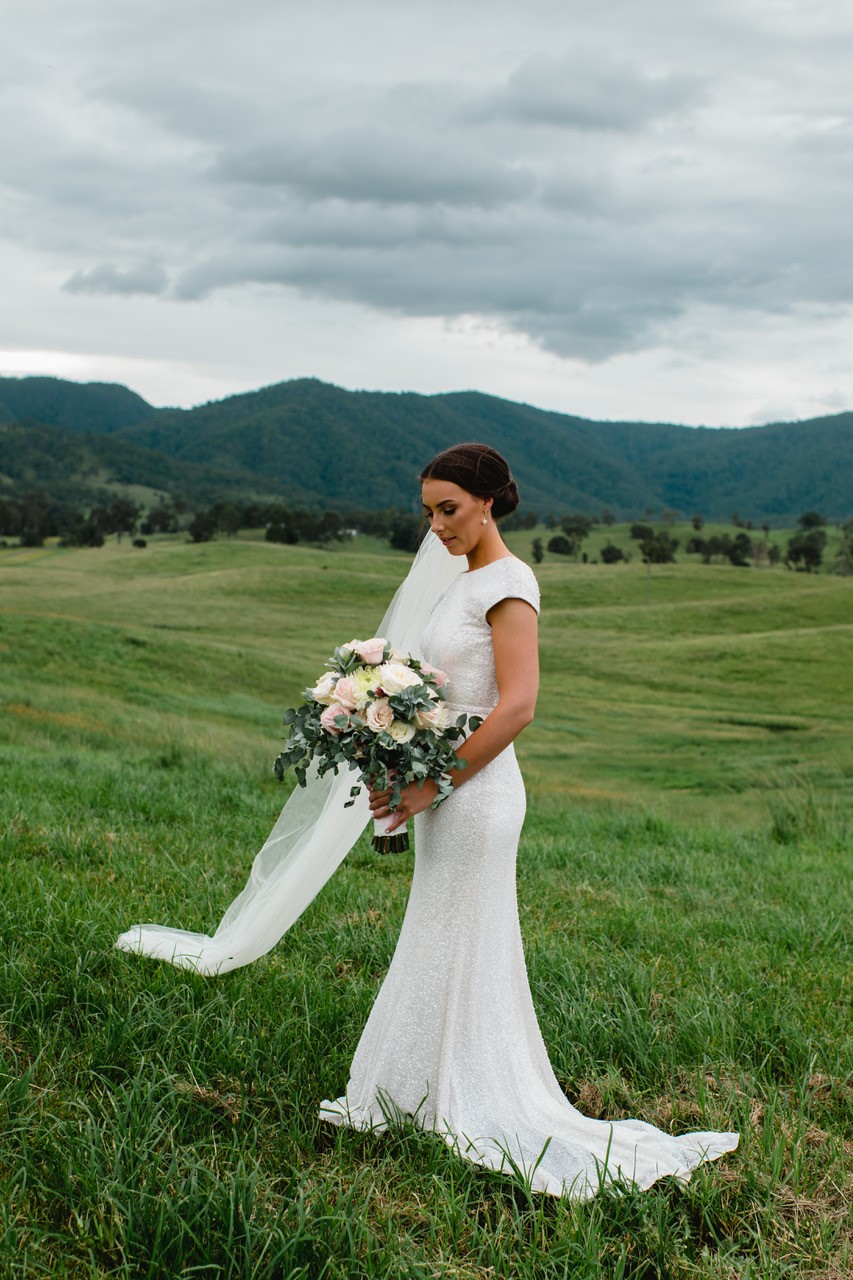 Real bride Elly wears the Annette wedding dress by Karen Willis Holmes; featuring cap sleeves with a high neck and low back.