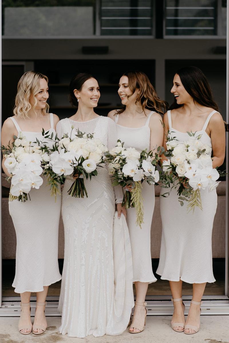 KWH bride Anna with her bridesmaids holding their bouquets. Anna wore the Cassie wedding dress.