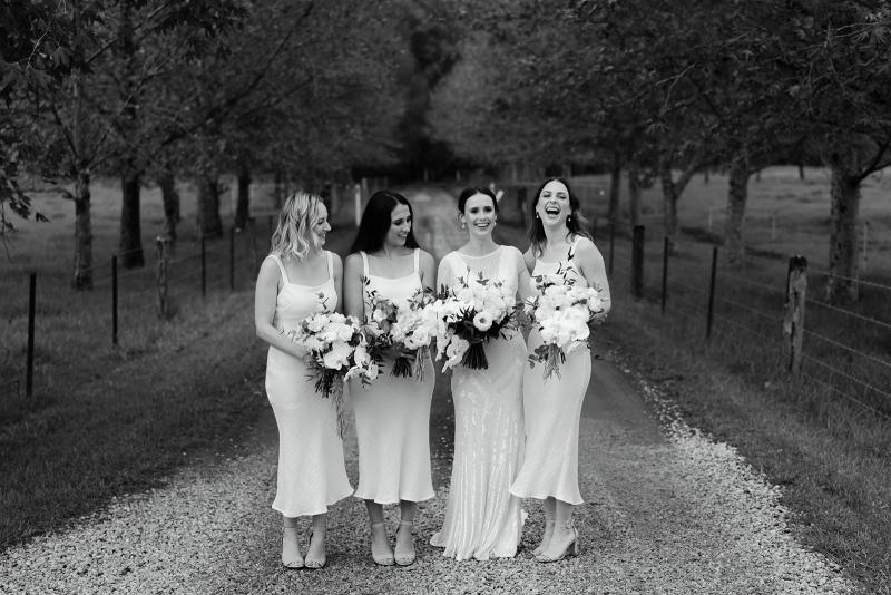 Karen Willis Holmes bride Anna and her bridesmaids; bride wearing the Cassie gown with an open back and long train.