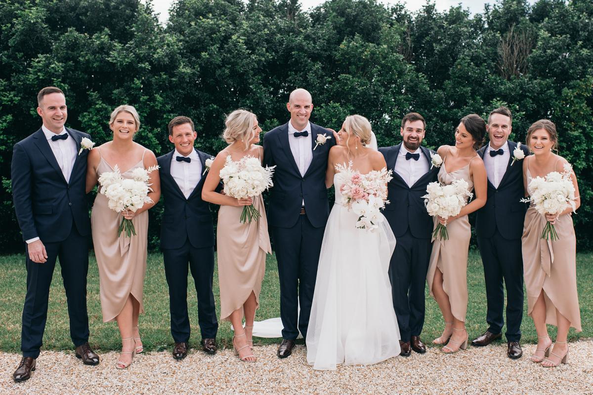 KWH bride Samantha and husband Adam with their wedding party. Bridesmaids in blush pink to match bouquets while the bride wears the Esther wedding dress.
