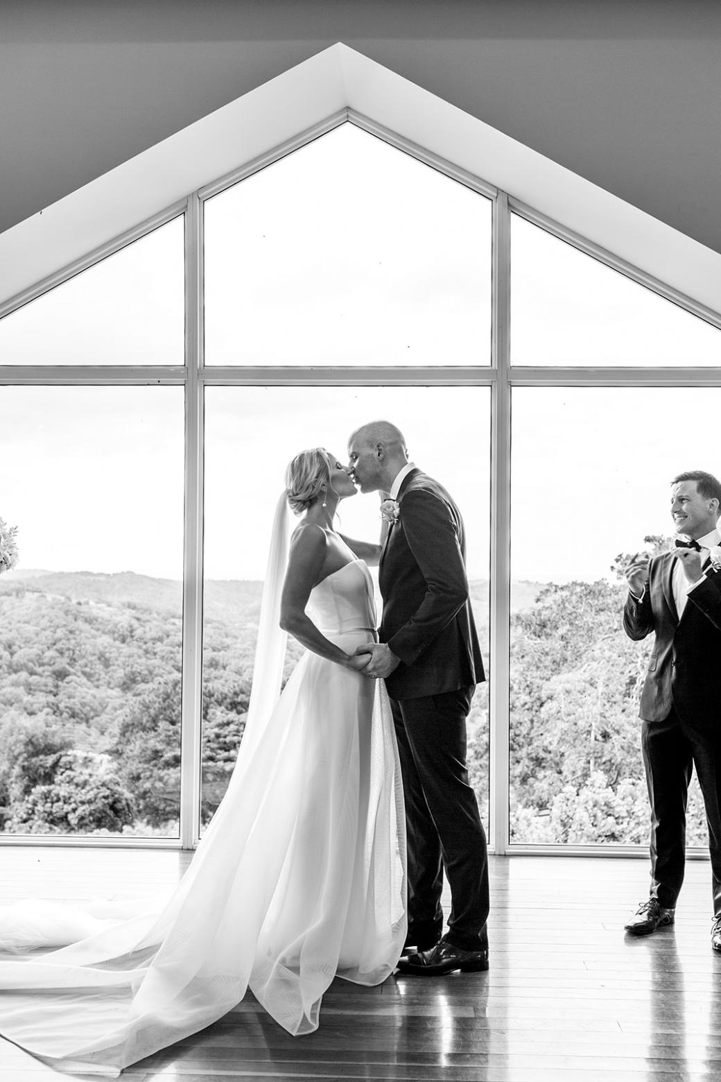 B&W image of KWH bride Samantha and husband Adam kissing; bride wearing the Esther wedding dress from our Bespoke Collection