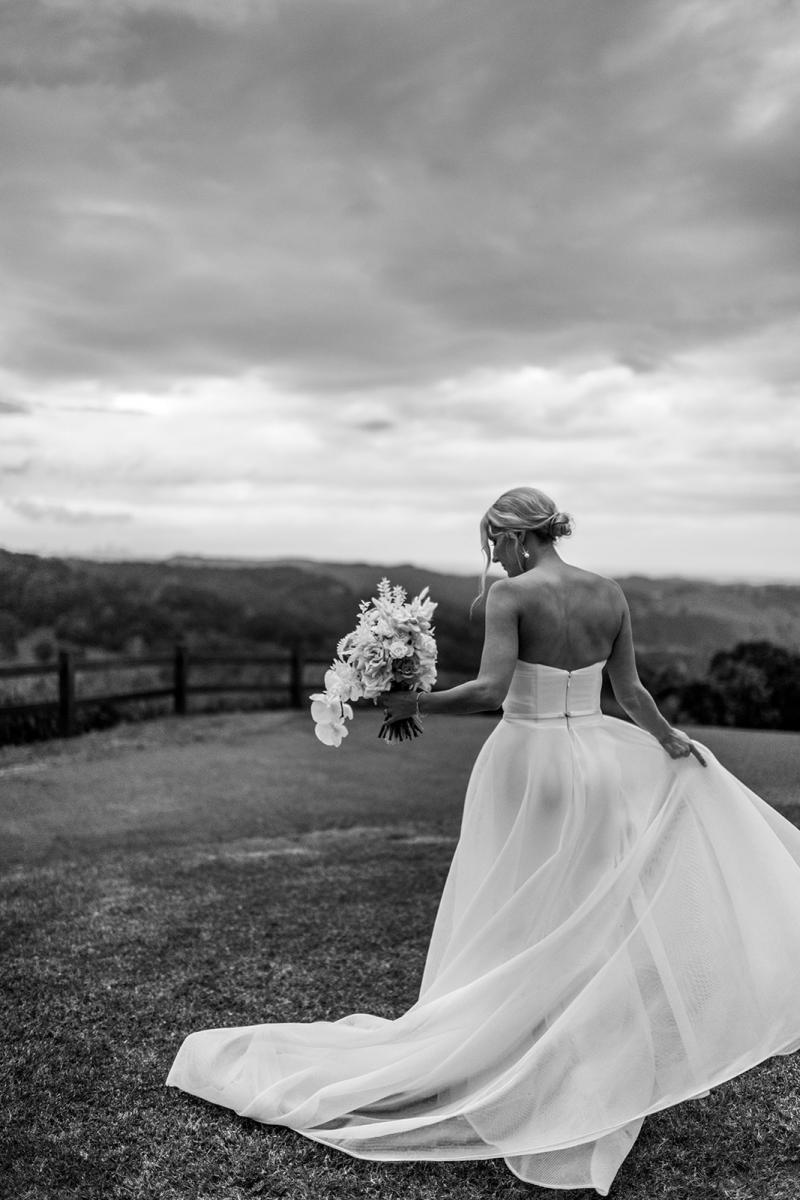 KWH bride Samantha holding her timeless bouquet, wearing the Esther wedding dress which features a front split, fitted base and long train.