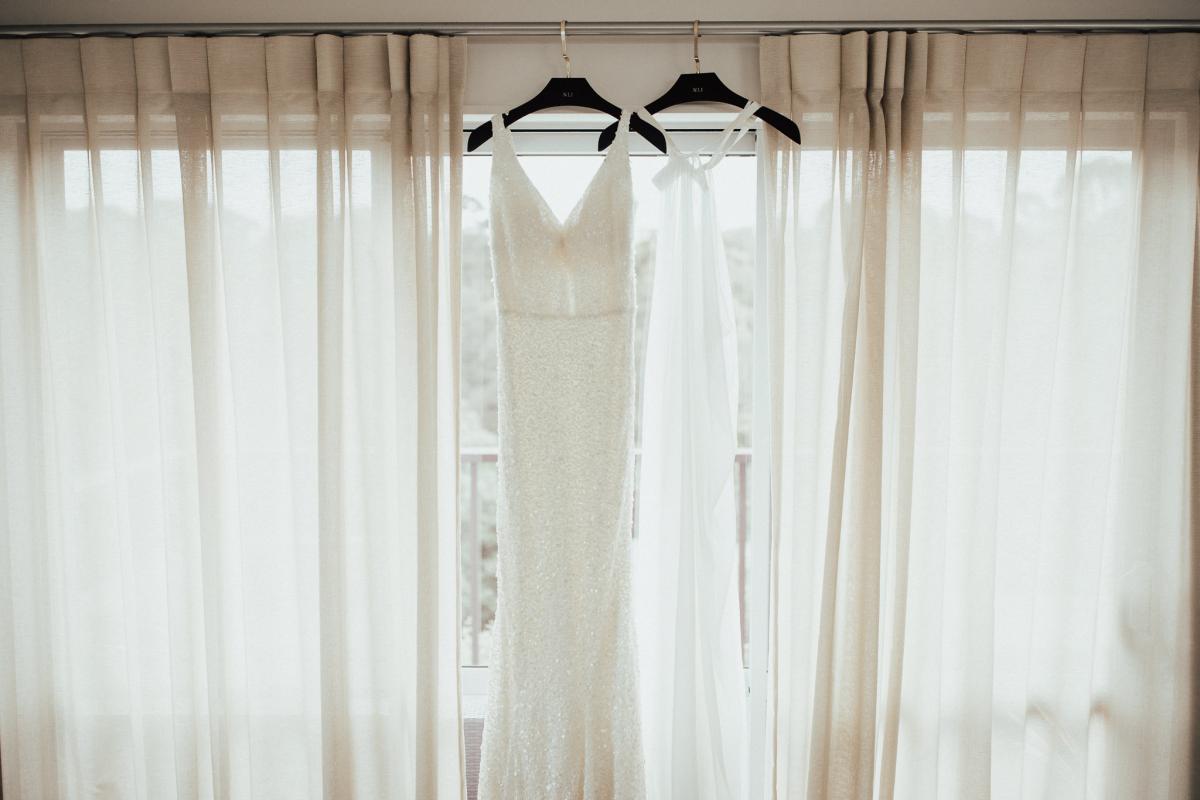 KWH bride Tash's Lola gown and Genevieve trains hanging from window.