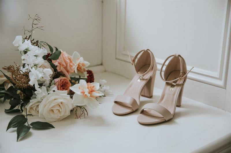 Real bride Lucy's wedding accessories, featuring colourful blooms and nude heels.