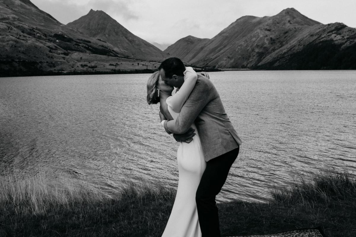 B&W image of KWH real bride Lauren and husband Will kissing on their wedding day. Lauren wears the timeless Nikki gown.