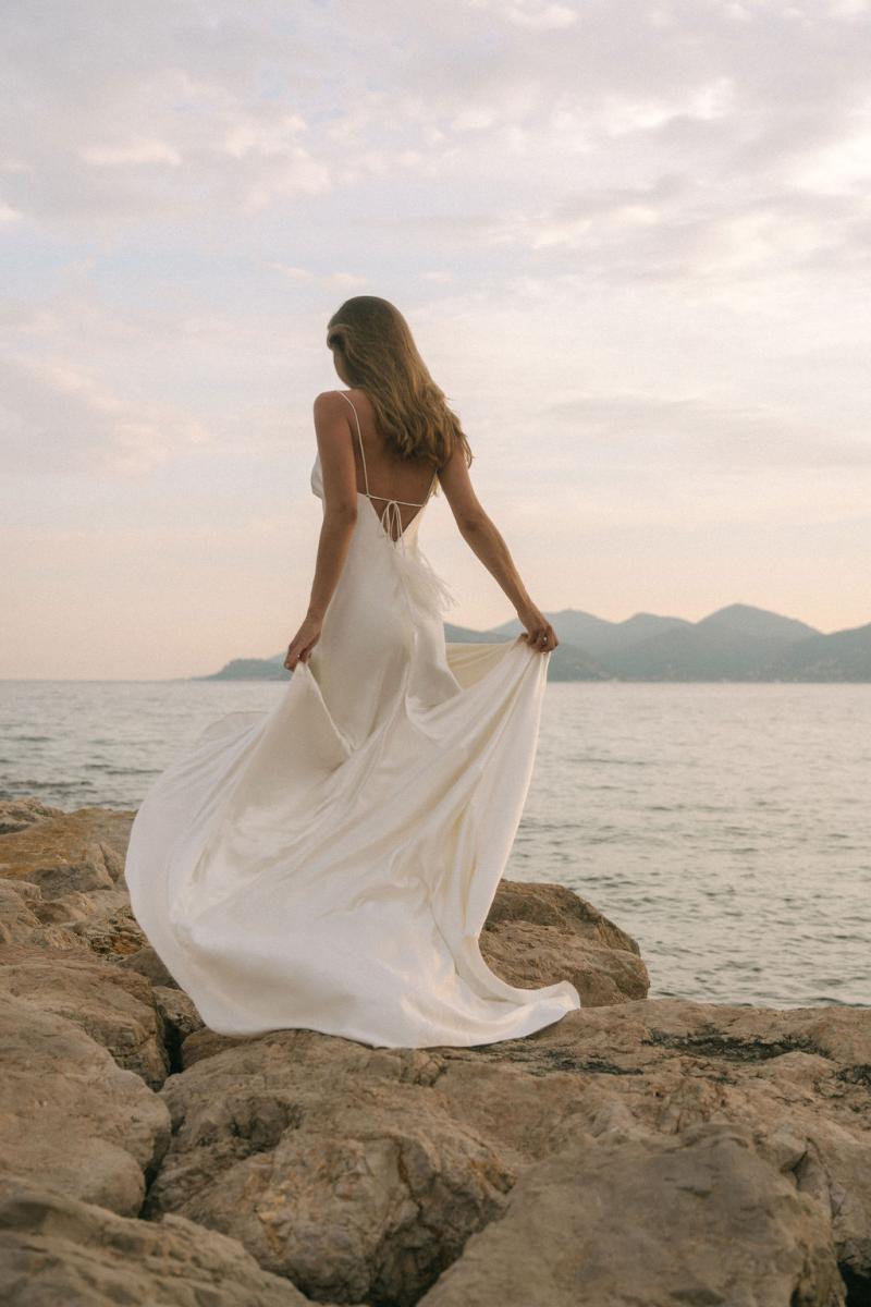 Model Ben Simmons wears the Sage gown, a minimal wedding dress from the Elope collection by Karen Willis Holmes.