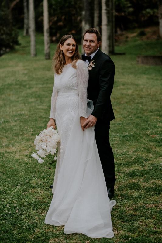 Real bride Penelope poses with husband David,wearing the Cassie gown and Oval Trains by modern bridal designer Karen Willis holmes.