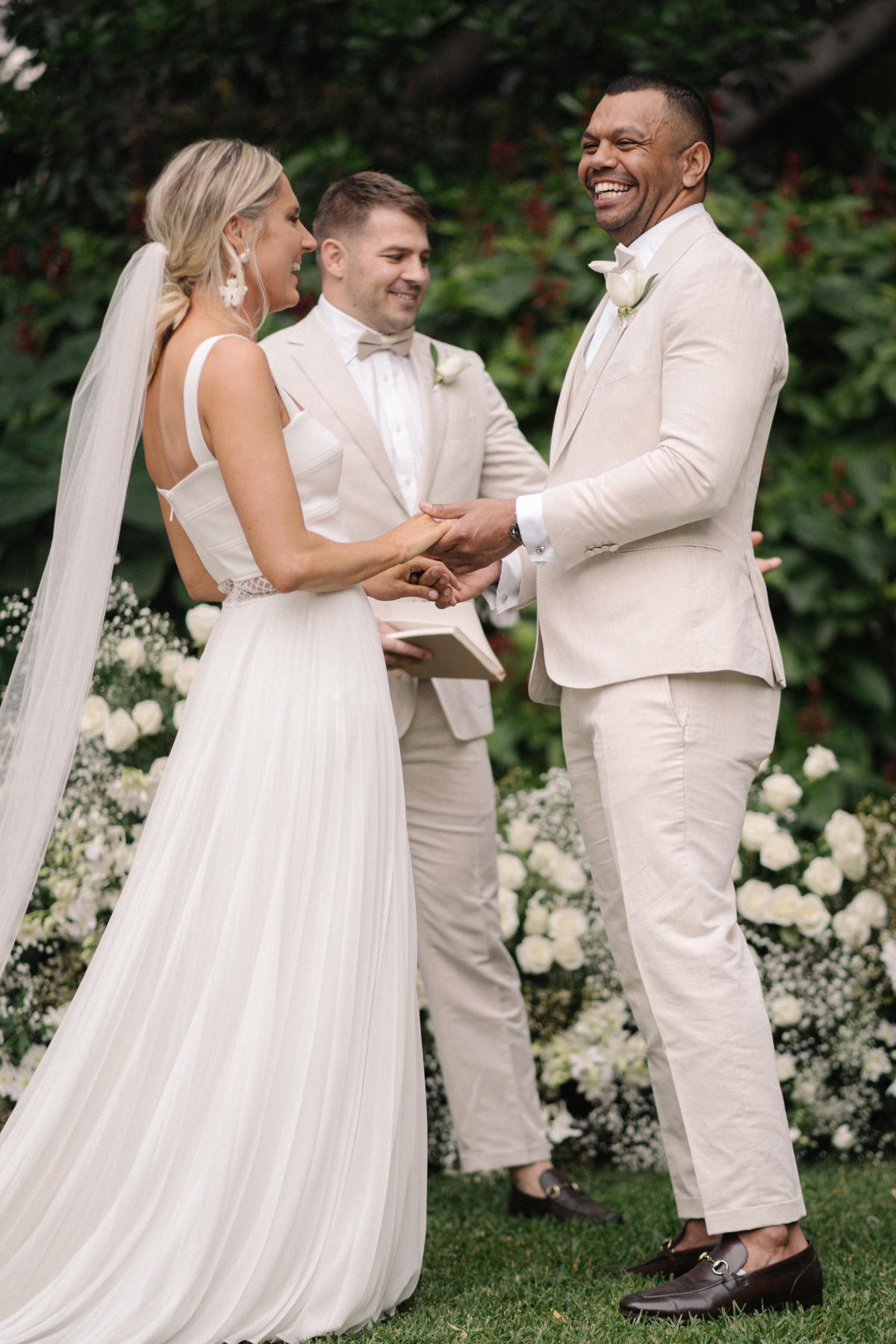 Real bride Maddi with husban Kurtley at alter, wedding featured on Vogue bridal, bride wearing the Daisy gown by Karen Willis Holmes.