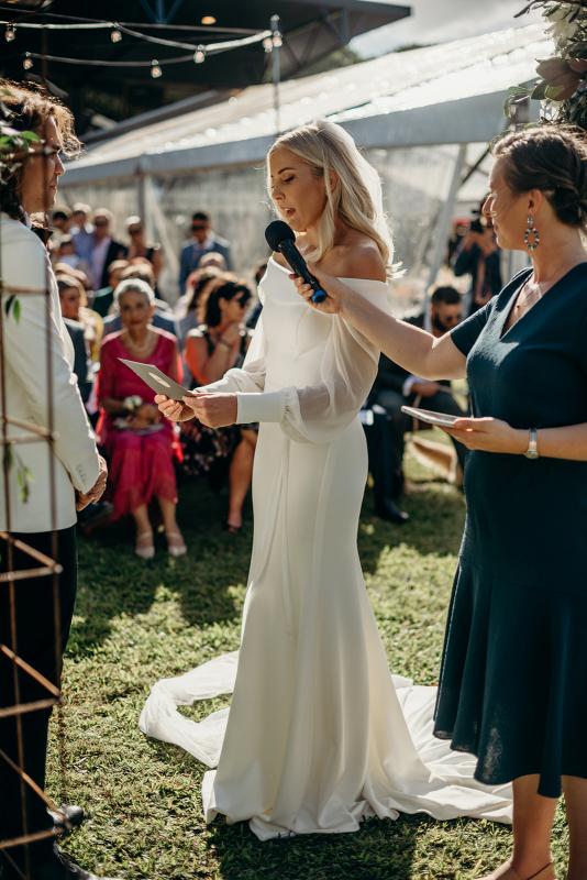 Real bride Hannah wears the Lauren gown; an off shoulder wedding dress with customised Nikki sleeves by Karen Willis Holmes, to wedding ceremony
