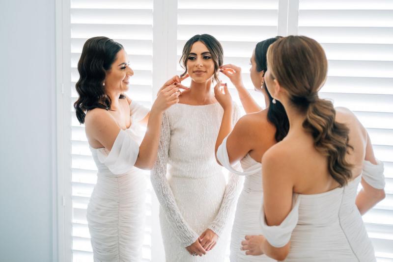 Real bride Katrina getting ready for wedding with bridesmaids, wearing the Margareta gown, a long sleeve backless wedding dress Karen Willis Holmes.