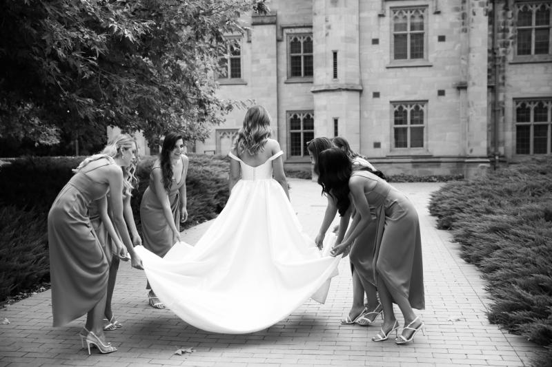 Real bride Valentina poses with bridesmaids, showing off the dramatic train of her Blake Camille gown; a traditional sweetheart neckline wedding dress by Karen Willis Holmes.