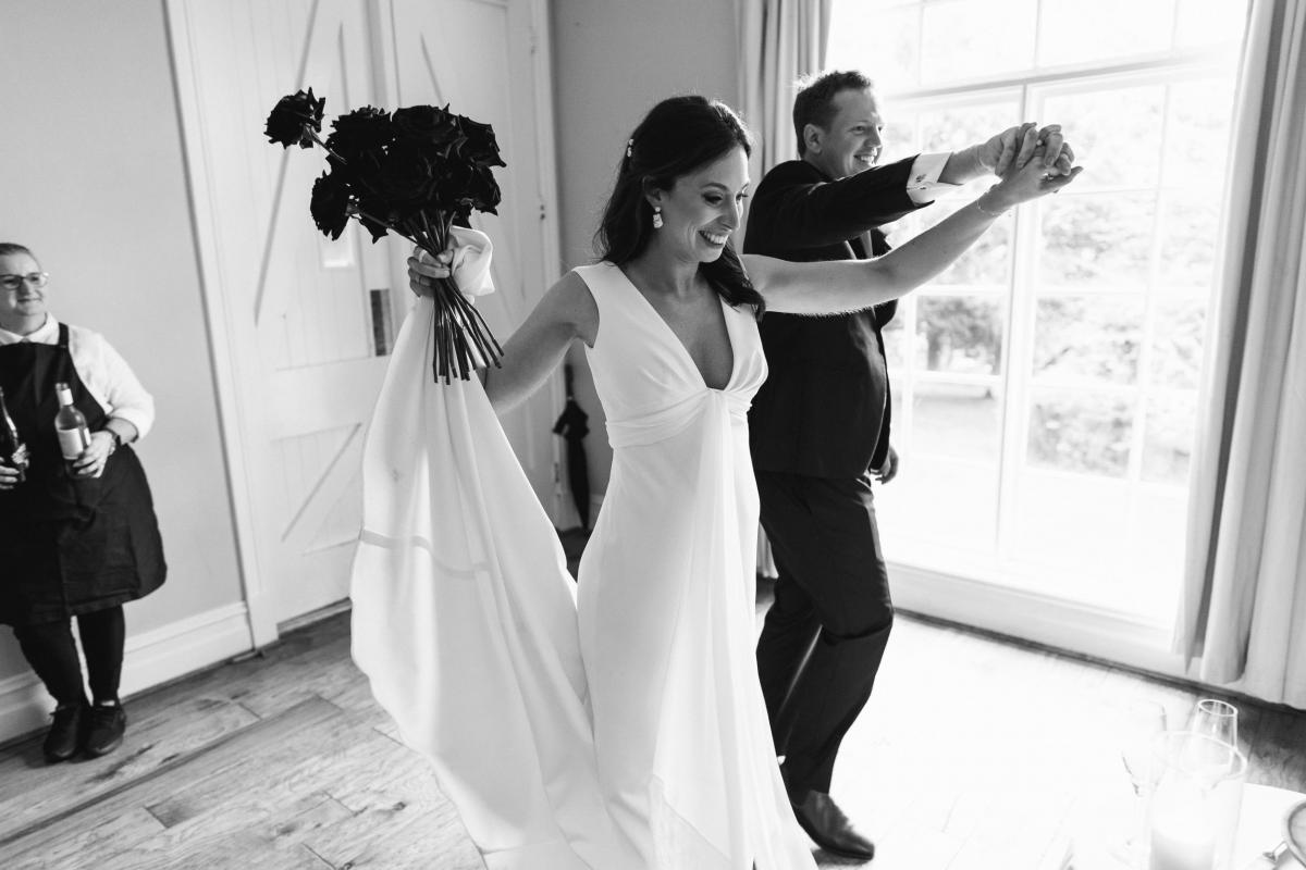 Real bride April dancing with her new husband, wearing the Arabella gown; a simple sheath wedding dress by Karen Willis Holmes.