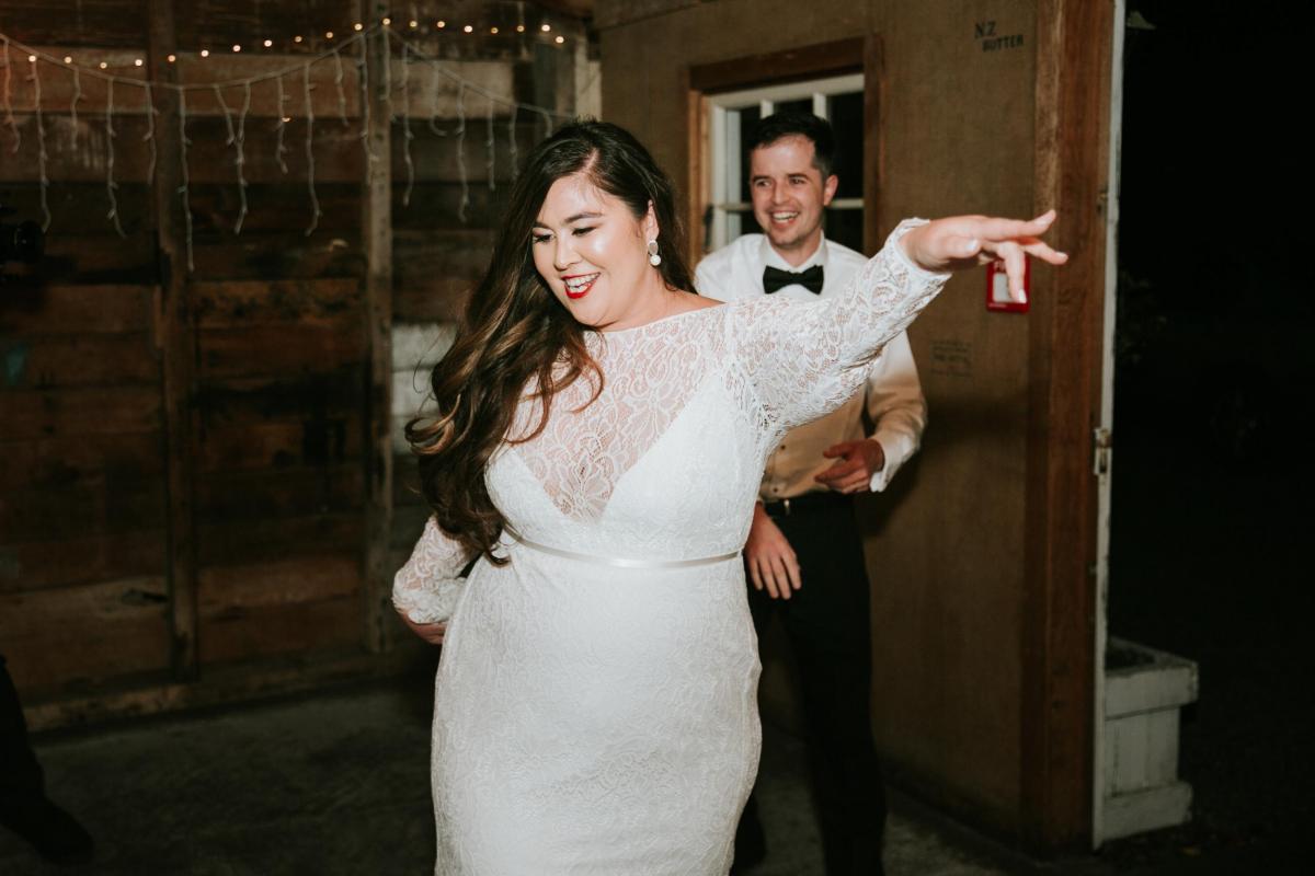 Real bride Jarna and husband Aden dancing the night away in rustic, New Zealand, reception venue wearing her comfortable lace Karina wedding dress.