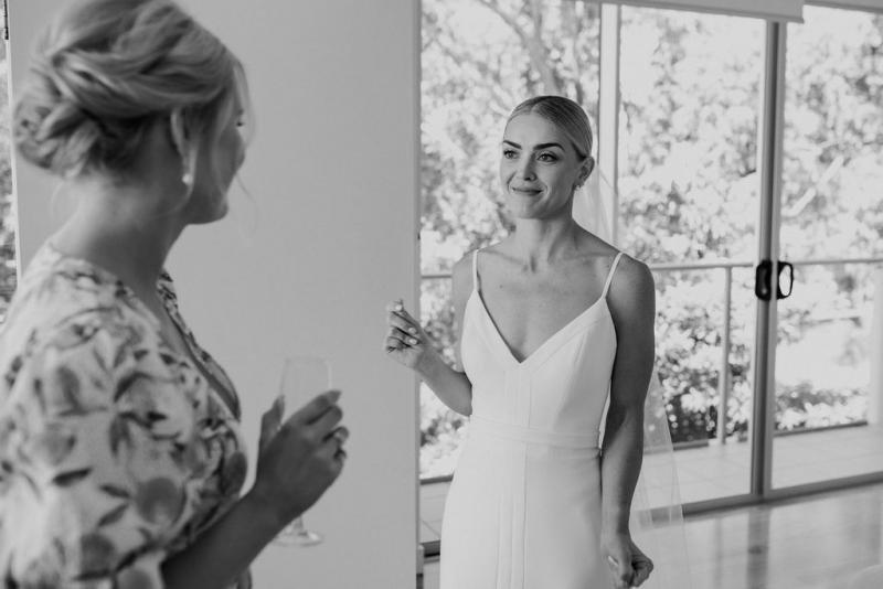 Real bride Kate getting ready for her wedding, wearing the Caroline gown; a simple v-neck wedding dress by Karen Willis Holmes.