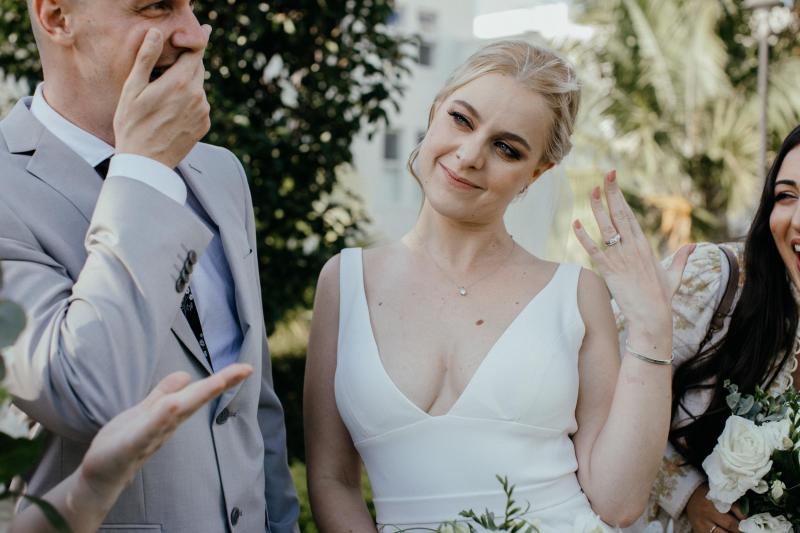 Real bride Eliza showing off her wedding ring as she also wears her simple Imogen wedding dress with v-neckline.