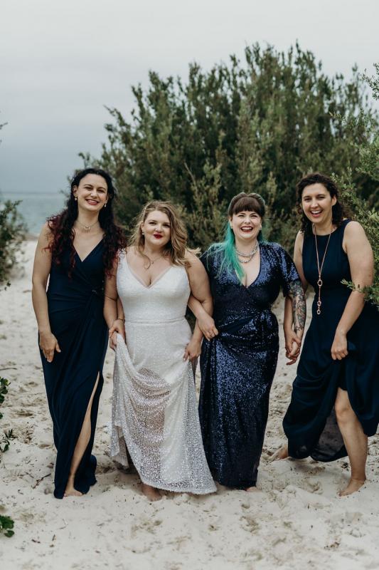 Real bride Annabel on the beach with her bridesmaids, wearing the Lotus gown by Karen Willis Holmes.