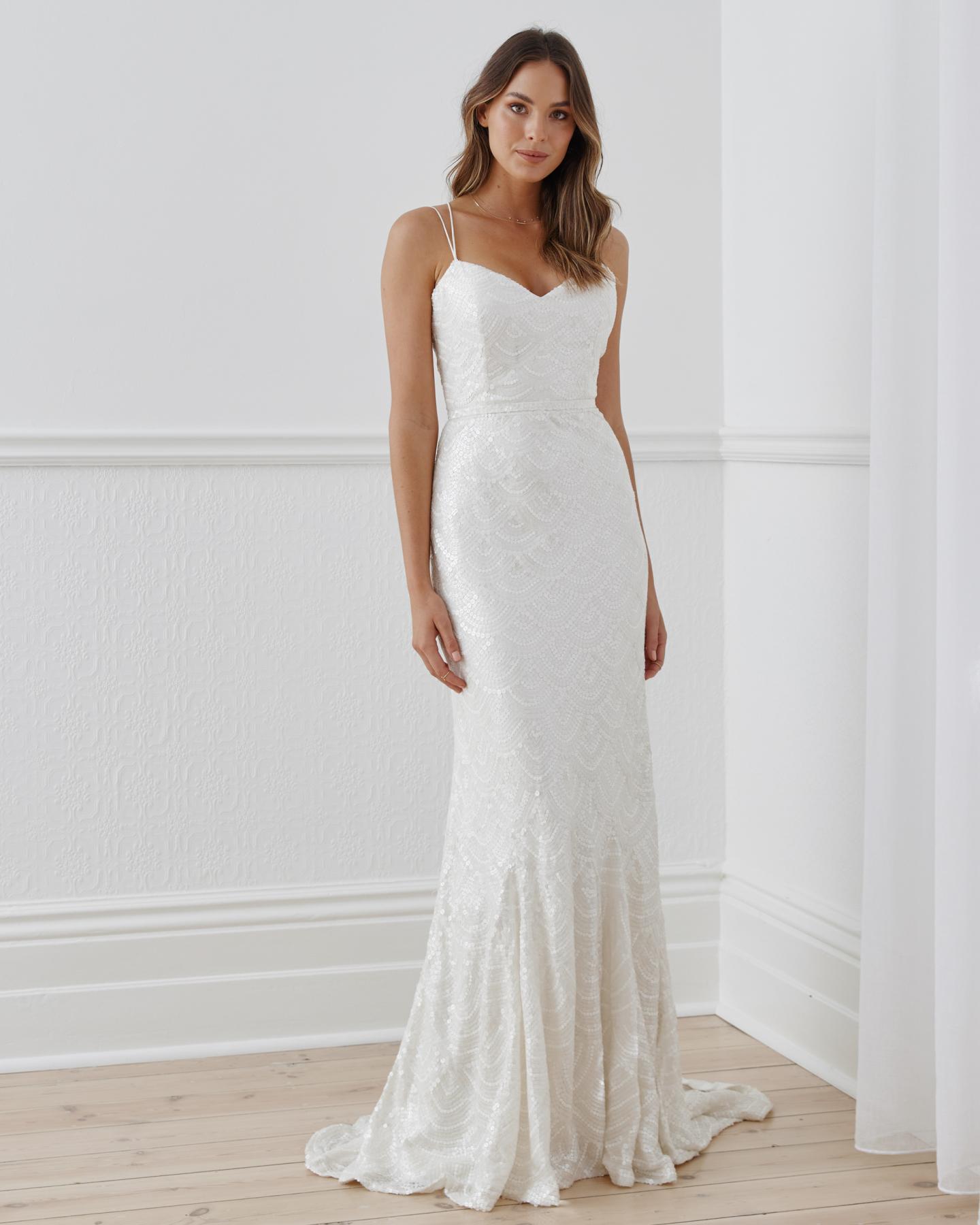 The Ellie gown by Karen Willis Holmes, a V-Neck open back, beaded fit and flare wedding dress with spaghetti straps.