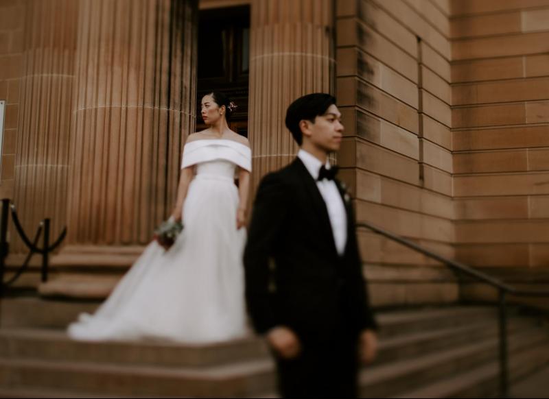 KWH real bride Sarah and Brian stand out front the art gallery. She dons the classic Kitty Joni gown with organza skirt and fitted bodice.