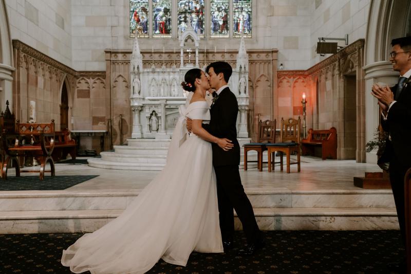 KWH real bride Sarah and Brian kissing after their vows in the church. She wears the classic bespoke gown Kitty Joni with tulle aline skirt.