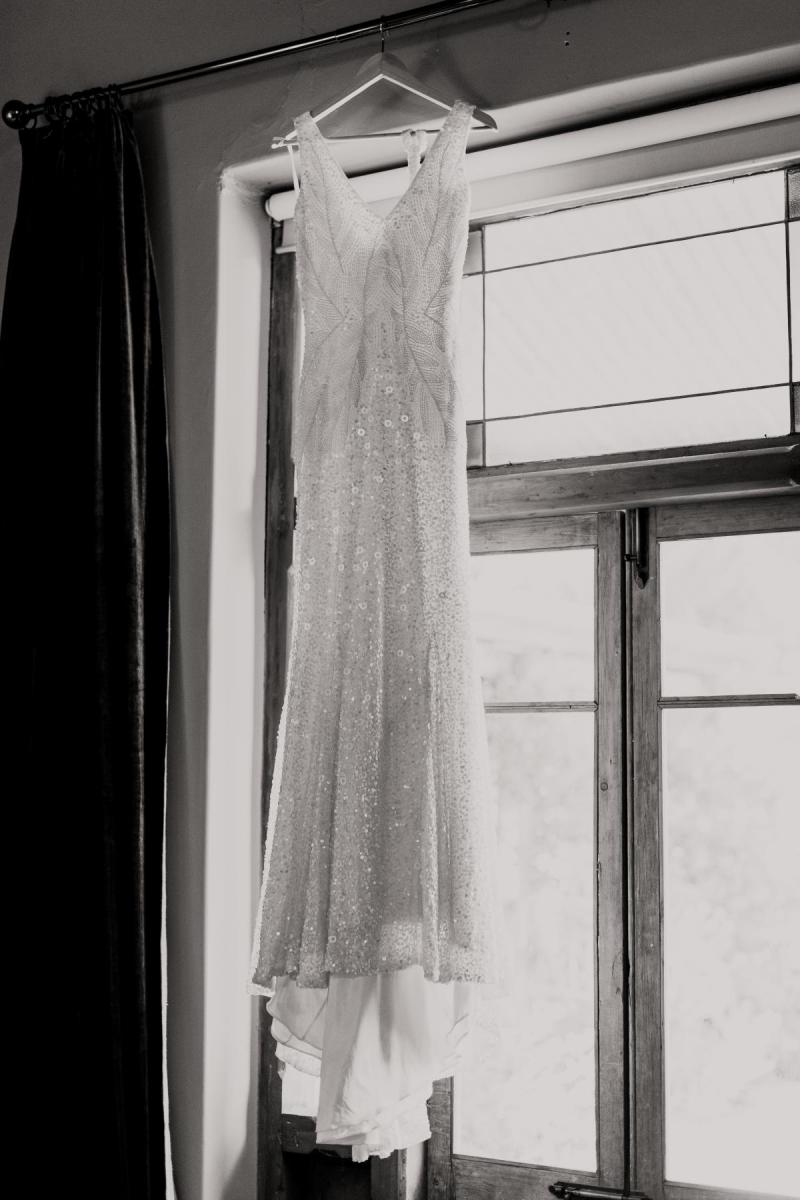 KWH real bride Bec's Luxe Olympia gown hanging in the window. The gown features organic inspired beads.