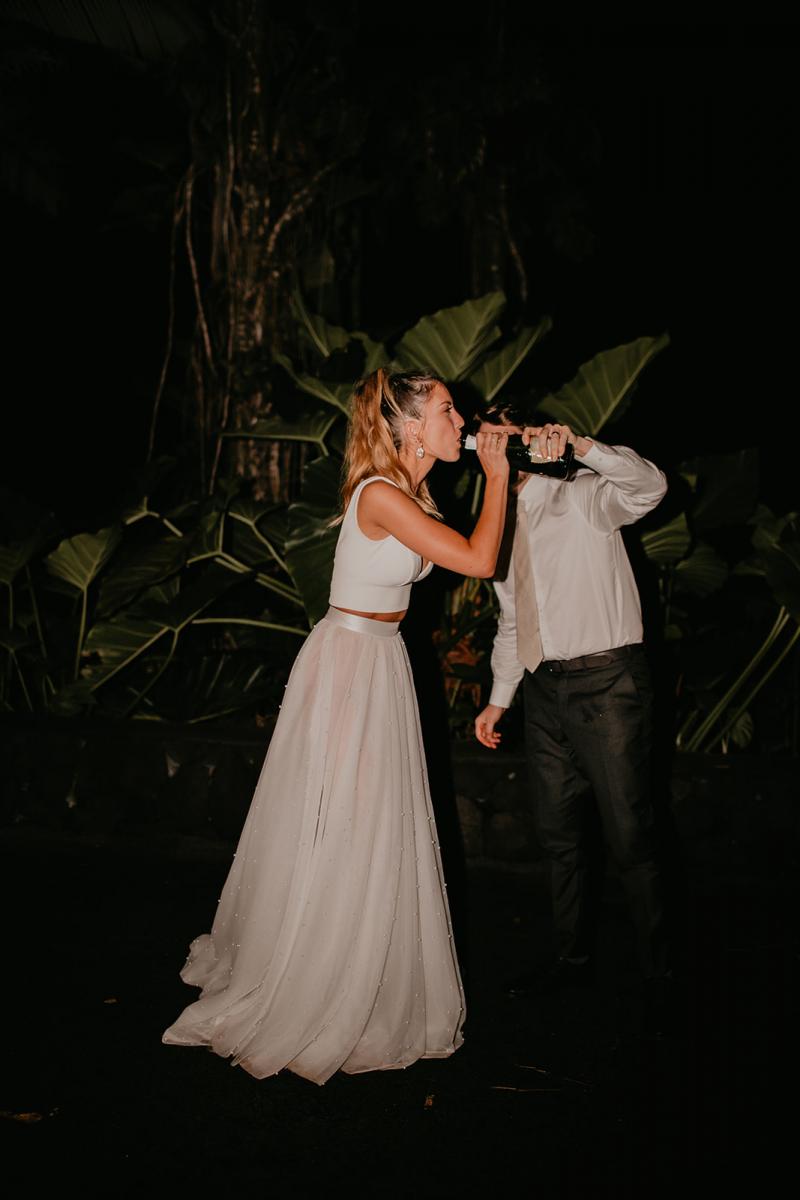 KWH real bride Jana sips champagne from the bottle. She wears the ivory Erin and Lea wedding set with aline skirt.