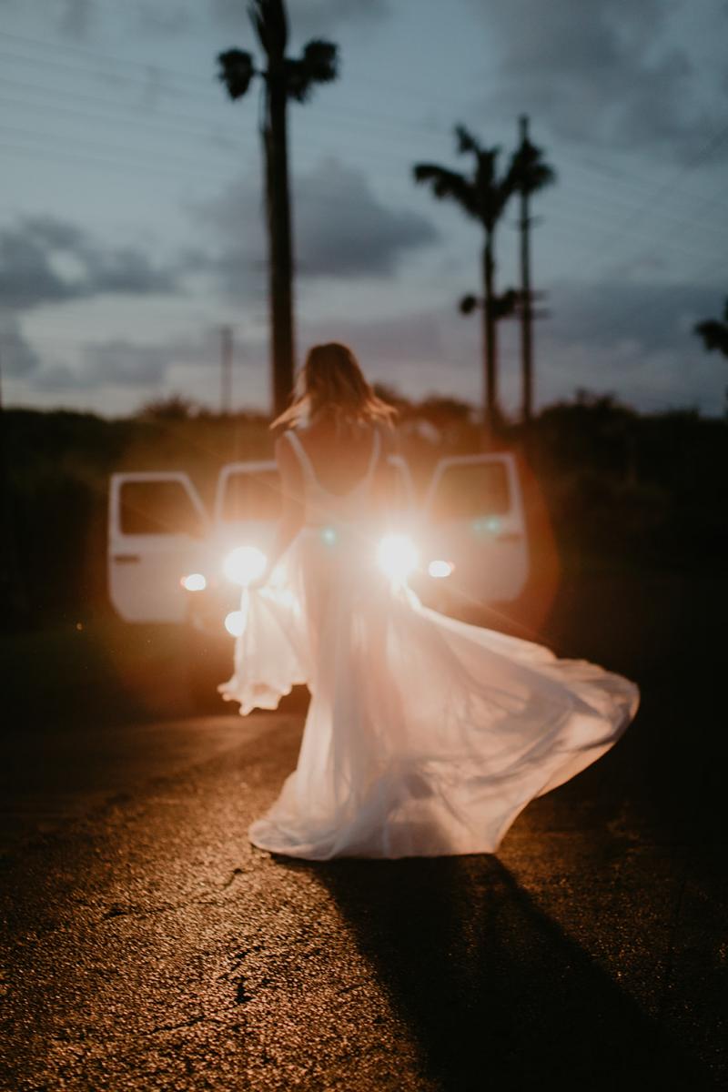KWH real bride Jana dances in her Erin and Lea two piece wedding dress set in front of the headlights of a jeep after her modern elopement.