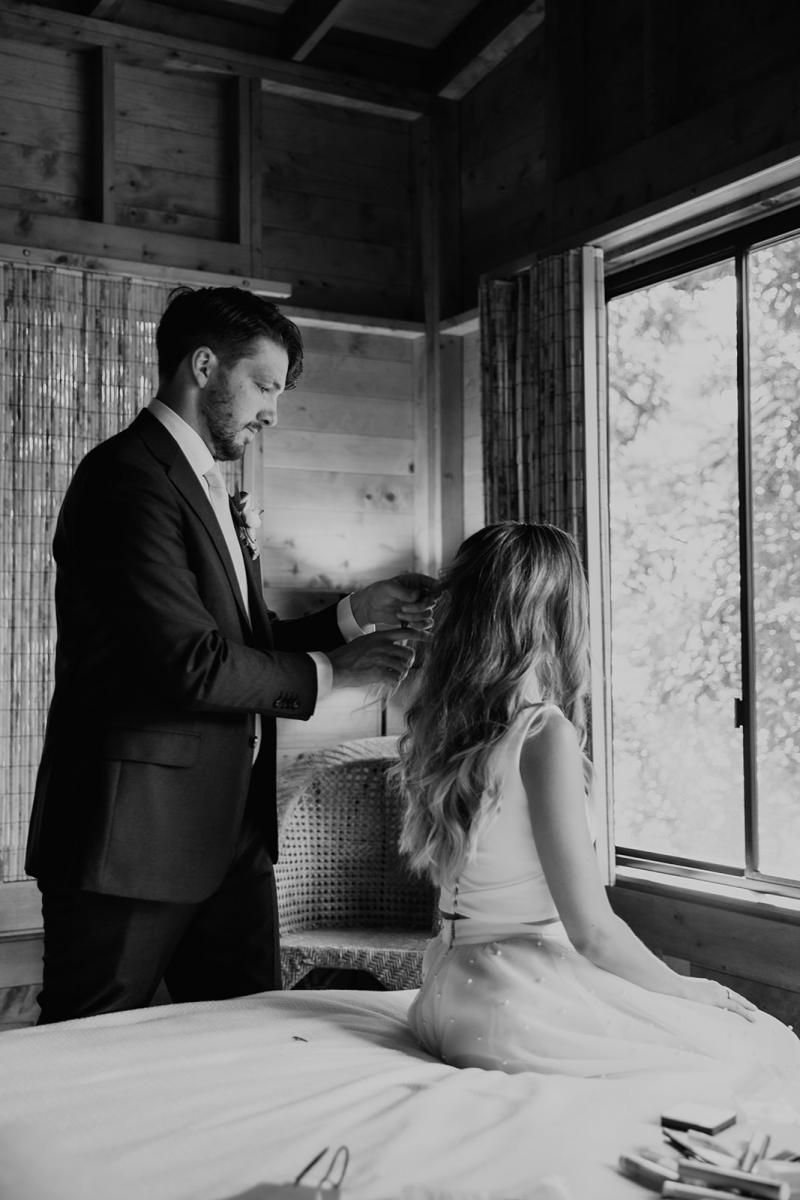 B&W photo of KWH real bride Jana getting her hair done by her loving husband Garret. She wears the seperate Erin and Lea bridal set with aline skirt and crepe bodice.