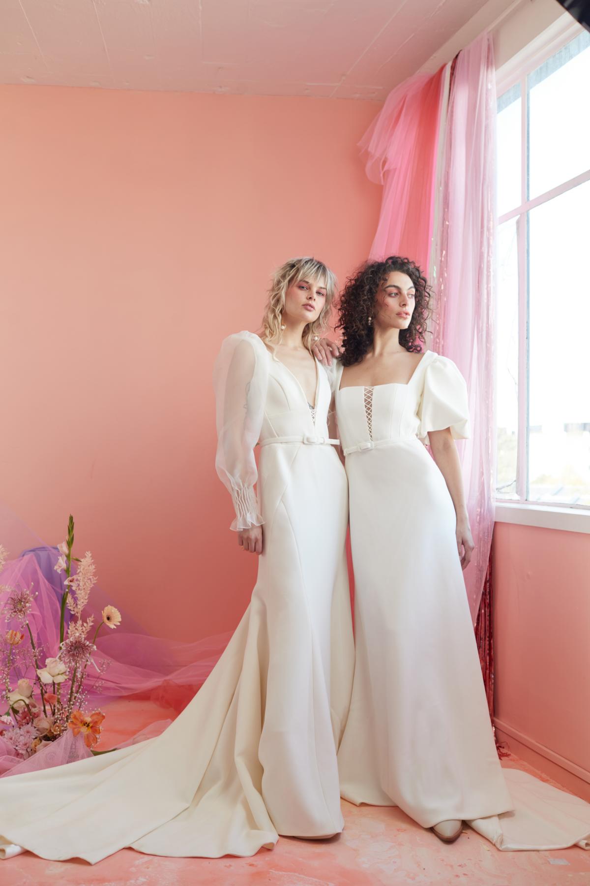 In this peachy pink image two models stand in their new modern wedding dress designs by KWH.