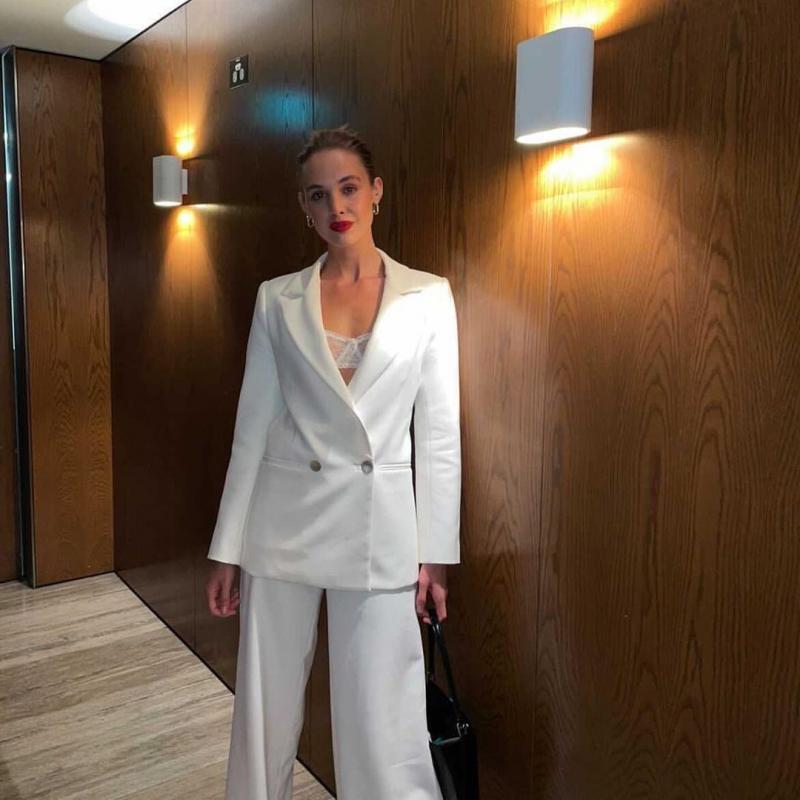 Laura Dewit stands in her alluring Charlie jacket and Danielle pant attire by KWH, a modern bridal suit with flared leg.