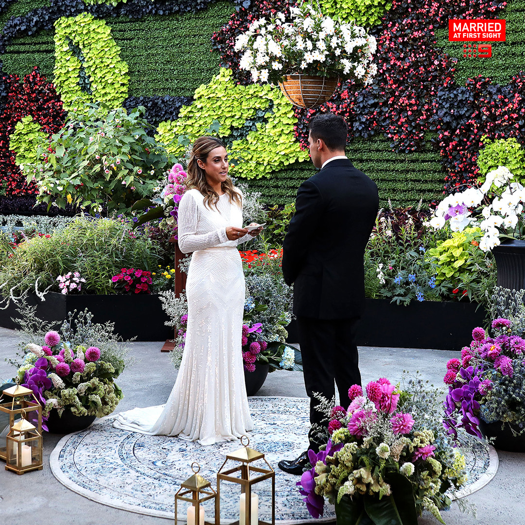 Kerry and John stand at their commit ceremony on MAFS Australia where she wears the stunning Cassie gown, a long sleeve high neck beaded wedding dress.