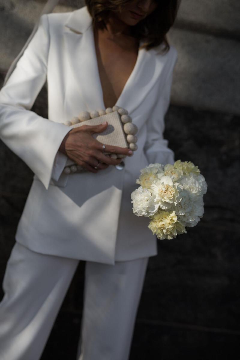 Megan Kellys bridal suit and minimal wedding flowers by Bloodwood botanica. Bridal clutch by Cult Gaiga