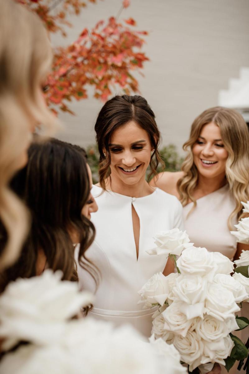 KWH real bride Jacqui with her bridesmaids as she wears the Clarissa gown, a modern high neck cap sleeve wedding dress.
