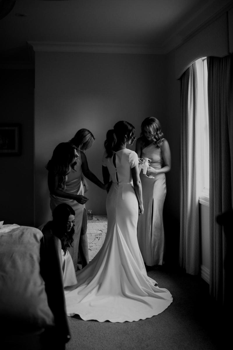 B&W image of KWH real bride Jacqui getting ready for her day in her Clarissa gown, a simple fit and flare modern wedding dress.