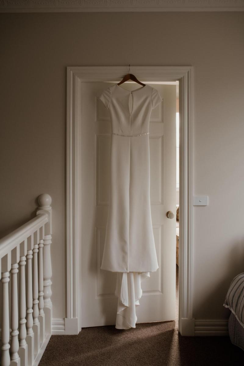KWH real bride Jacqui's Clarissa gown hanging in the doorway.