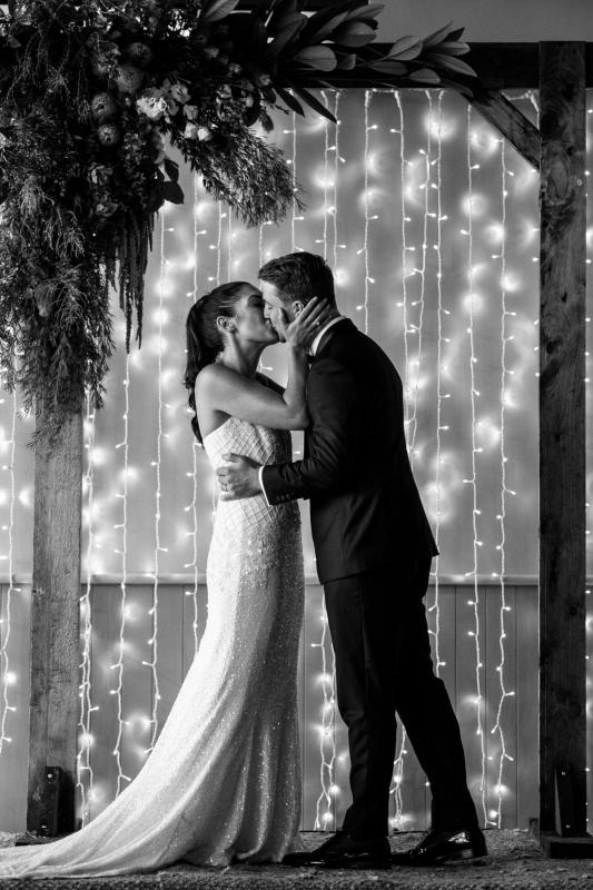 Real bride Ruby kissing her man at the alter wearing her beaded Darcy gown by Karen Willis Holmes.