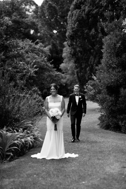 Dan approaches Real Bride Emily for their first look. She wears the crepe Violet gown by KWH with wide straps.