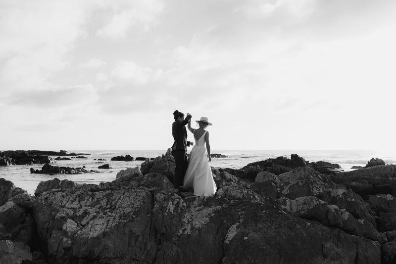 Taryn Camille_Karen Willis Holmes_Emma & Emily - Brides seen dancing along the rocks after their gorgeous elopement