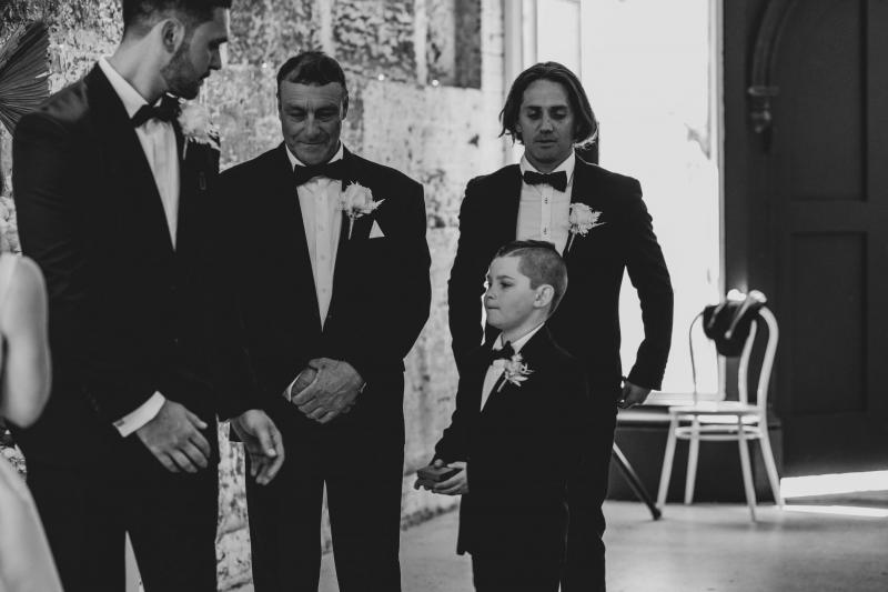 Real bride Shenea's fiance and sons waiting for her to arrive in this B&W photo.