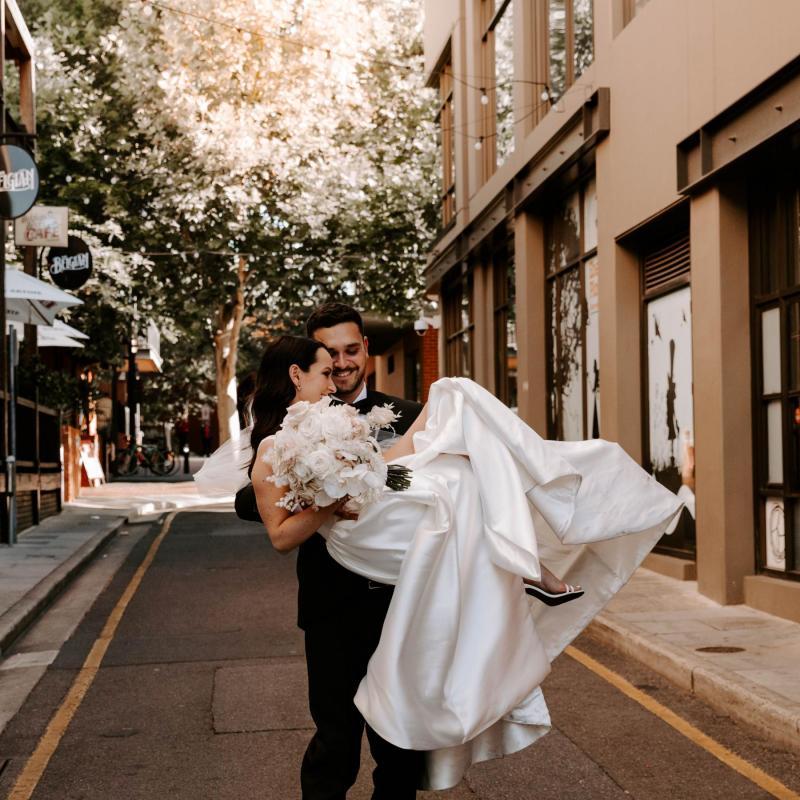 KWH real bride Shenea is swept away by new husband Lain in the streets of Adelaide. She wears the minimalist Taryn Camille gown.