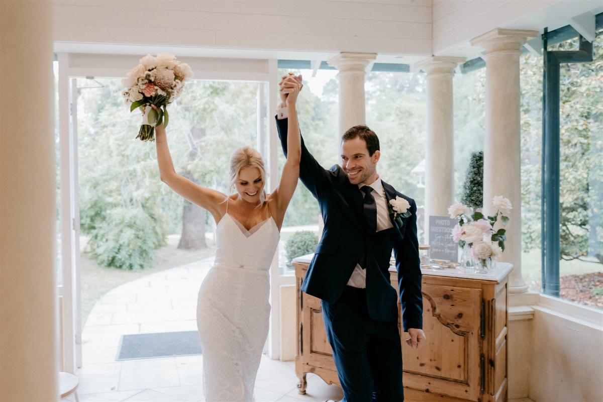 Bride in Elodie lace wedding dress by Karen Willis Holmes holding timeless bridal flowers