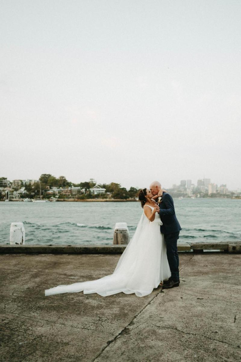 Bride and groom in Sydney Harbour, bride wearing AISHA gown by Karen Willis Holmes; a modern Bespoke wedding dress