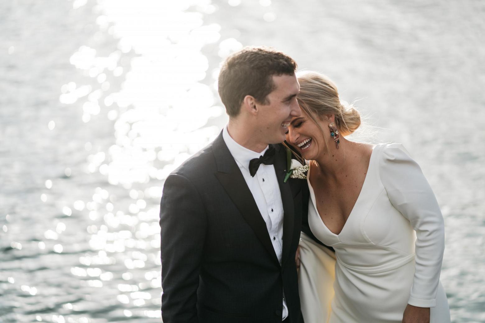 KWH bride Jordana celebrating with husband Mitch; holding her bridal bouquet.