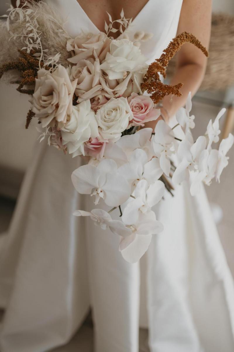 Kelsi wears the Leonie Melanie gown; a V-neck, A-line, simple wedding dress, for her Queensland wedding with natural bridal bouquet