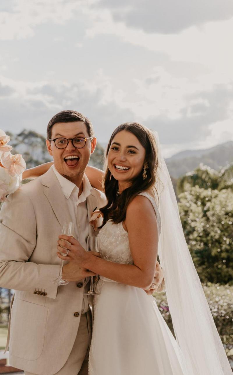 Leah celebrating her wedding with husband; wearing the FONTANNE wedding dress by Karen Willis Holmes.